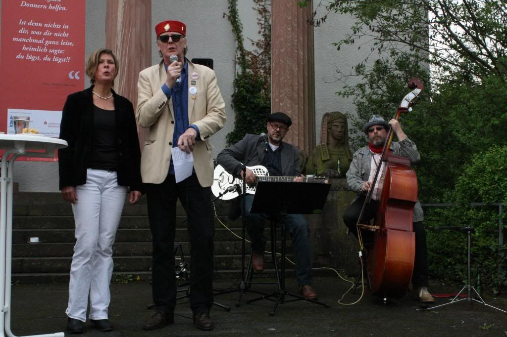 Petra Bassus und Reiner Lenz singen, im Hintergrund die fabelhafte Büchner-Bande 